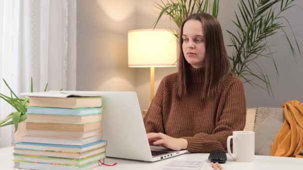 不幸な白人ダークハイレッド女性は 自宅でテーブルでラップトップに取り組む茶色のセーターで頭が痛みを感じる長時間働く — ストック動画