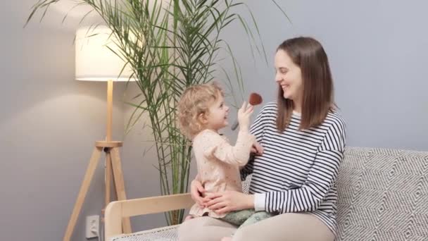 귀여운 소파에 앉아있는 어머니와 브러시 본딩과 메이크업을하는 아늑한 가족의 순간을 — 비디오