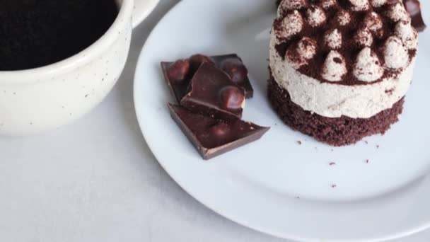 令人陶醉的巧克力令人愉悦 陈列的是烹调工艺 美味的双层蛋糕和盘中的巧克力 并配上一杯热咖啡或浅色背景的茶 — 图库视频影像
