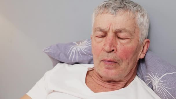 Ernstig Geconcentreerde Blanke Volwassen Grijze Man Wit Shirt Liggend Bed — Stockvideo