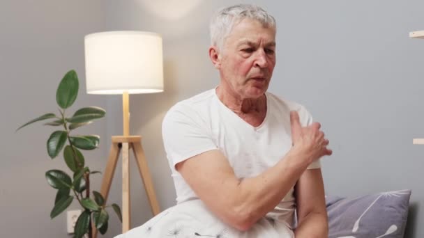 Starší Šedovlasý Muž Trpící Bolestivým Zraněním Sedí Uvnitř Masíruje Rameno — Stock video