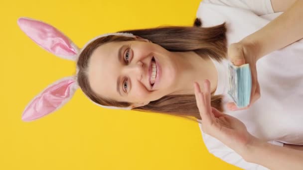 Вертикальное Видео Радостная Белая Женщина Повязке Кроличьих Ушей Сидящая Желтом — стоковое видео