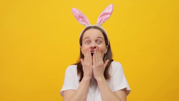 Удивлённая Темноволосая Женщина Повязкой Ушах Кролика Позирующая Изолированно Желтом Фоне — стоковое видео