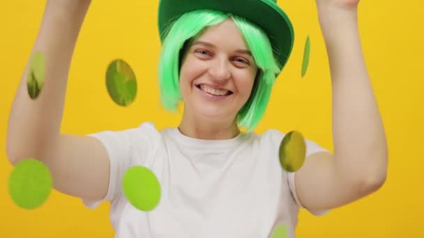 かわいい笑顔のセントパトリックデイレプチャンモデル 黄色の背景に隔離された緑の帽子の女性 幸せなイベントのお祝いの間に良い遊び心のある気分 — ストック動画