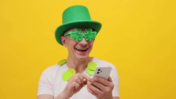 Veselý Muž Nosí Zelený Leprikón Stranický Klobouk Izolované Přes Žluté — Stock video
