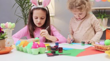 Paskalya yumurtası dekorasyonu. Çocuklar paskalya yumurtası boyası konusunda yaratıcı olurlar. Tatil için canlı yumurta tasarımları. Küçük kardeşler evlerinde paskalya yumurtası boyuyor.