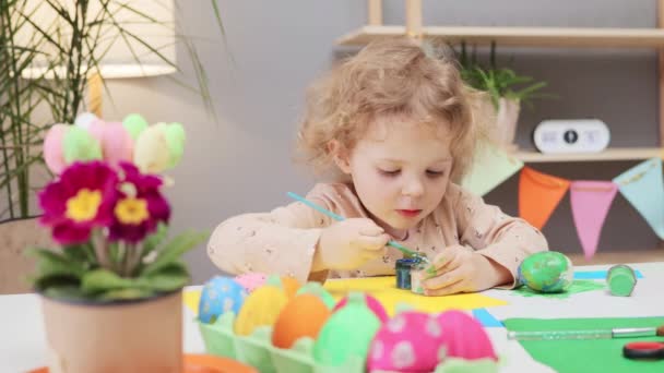 赤ちゃんのイースターエッグの絵 アートイースターのお祝い カラフルな卵の装飾 お祝いの家のインテリアでイースターエッグを描く小さな幼い幼い少女 — ストック動画