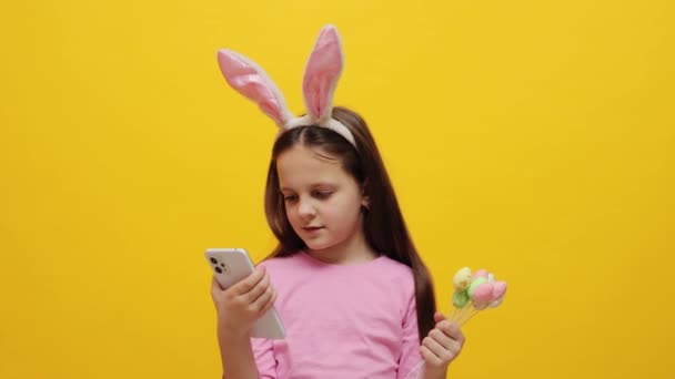 Urocza Dziewczynka Nosi Różowe Uszy Królika Opaska Gospodarstwa Pop Ciasta — Wideo stockowe