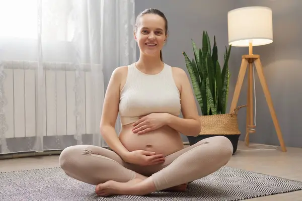 Pretty Smiling Delighted Pregnant Woman Wearing Beige Clothing Sitting Crossed — Stock Photo, Image