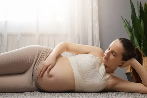 Relaxed Brown Haired Pregnant Woman Wearing Beige Clothing Lying Floor — Stock Photo, Image