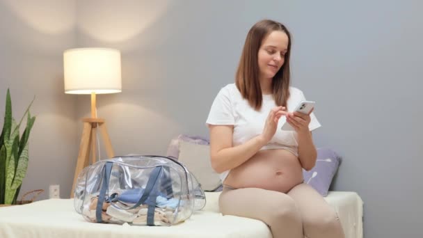 Encantada Mujer Embarazada Sonriente Utilizando Aplicación Móvil Para Comprobar Lista — Vídeos de Stock