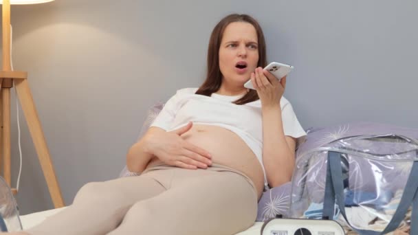 Šokovaný Bolestivé Těhotné Ženy Sobě Bílé Tričko Volání Lékař Sedí — Stock video