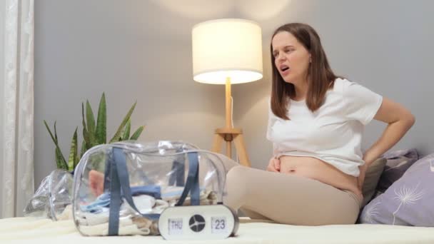 Болезненные Схватки Запоздалая Беременная Женщина Страдает Боли Спине Сидя Кровати — стоковое видео