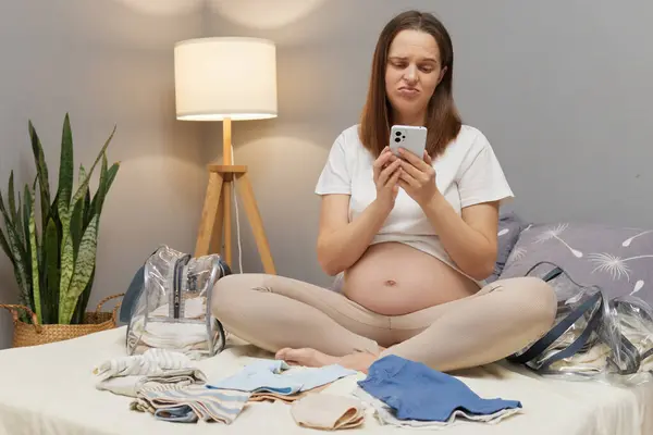 Unhappy Displeased Pregnant Woman Sitting Bed Bare Belly Packing Clothing — Stock Photo, Image