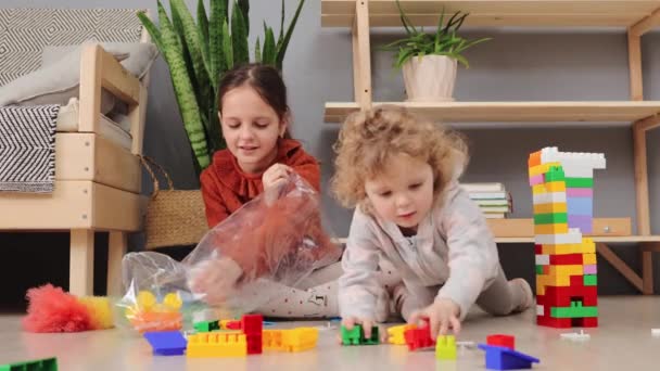 Маленькие Девочки Братья Сестры Играют Разноцветными Игрушечными Блоками Гостиной Полу — стоковое видео