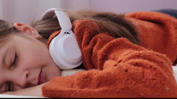 用无线耳机睡觉的可爱的棕色头发的小女孩醒来后 震惊而害怕的眼睛在床上播下梦魇般的孩子 — 图库视频影像