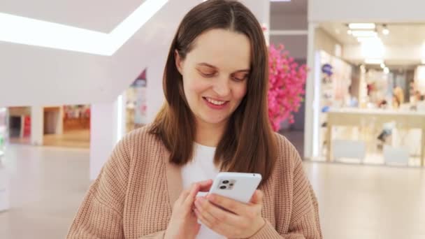 Lächelnde Attraktive Frau Posiert Modernem Einkaufszentrum Und Hält Smartphone Der — Stockvideo