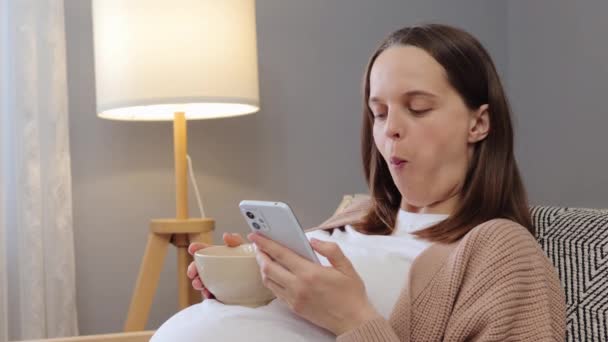 Mujer Embarazada Caucásica Cabello Castaño Usando Teléfono Inteligente Mientras Come — Vídeos de Stock