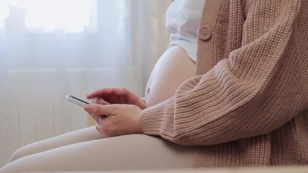 Nerozpoznatelná Těhotná Žena Sedí Pohovce Obývacím Pokoji Pomocí Smartphone Prstem — Stock video