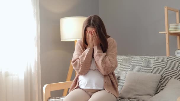 年轻的棕色头发孕妇坐在沙发上哭泣 改变了怀孕的心情 表达了怀孕时的悲伤和悲伤 — 图库视频影像