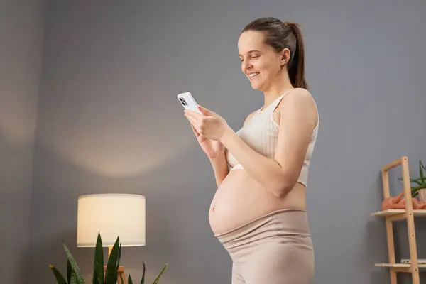 Stylish Pregnant Woman Wearing Beige Sportswear Posing Her Room Browsing — Stock Photo, Image