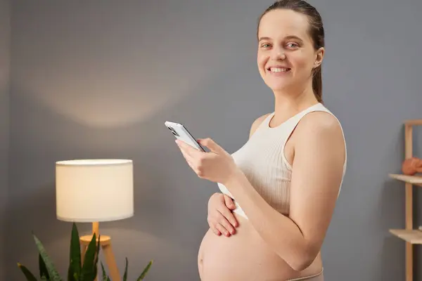Smiling Pregnant Woman Wearing Beige Top Stroking Her Bare Tummy — Stock Photo, Image