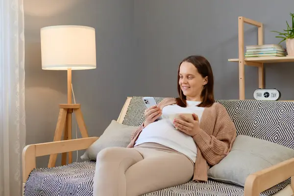 Charming Relaxed Pregnant Young Woman Using Her Smartphone While Having — Stock Photo, Image