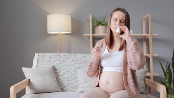Ohälsosam Sjuk Gravid Kvinna Som Använder Nässpray Medan Sitter Soffan — Stockvideo