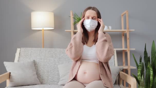 Chora Kobieta Ciąży Nosząca Maskę Medyczną Siedząca Kanapie Salonie Cierpiąca — Wideo stockowe