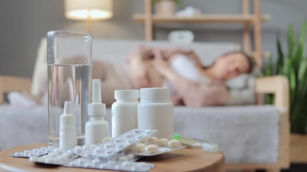 妊娠治療について インフルエンザに苦しんでいる間 自宅の女性のソファーで不健康な妊娠中の女性との多種多様な薬のクローズアップ — ストック動画