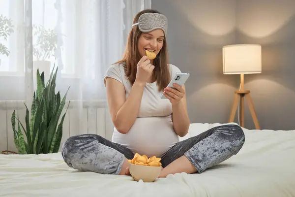 Attractive Beautiful Pregnant Woman Using Mobile Phone Eating Potato Chips — Stock Photo, Image