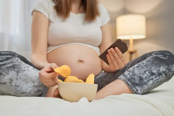 Unrecognizable Pregnant Woman Smartphone Hands Eating Chips While Scrolling Online — Stock Photo, Image