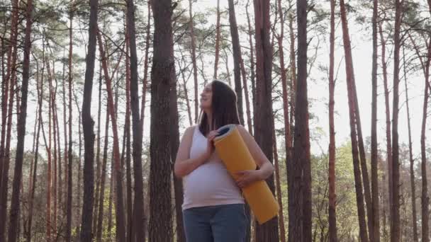 Verrukkelijke Sportieve Zwangere Vrouw Houdt Mat Handen Staand Het Bos — Stockvideo