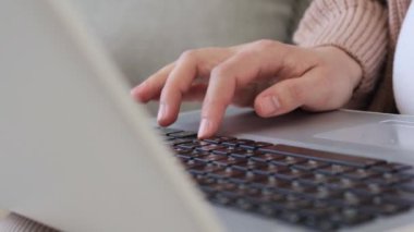 Koltuğunda oturan hamile kadının elleri klavye üzerinde dizüstü bilgisayar kullanarak internet üzerinden alışveriş için ödeme yapan kredi kartı bilgilerini girerken.