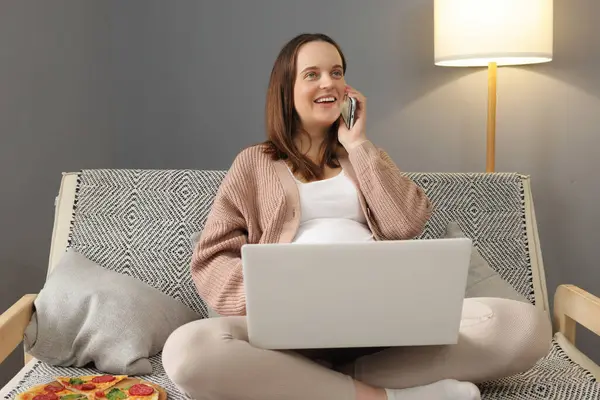 Smiling Caucasian Pregnant Woman Using Laptop Talking Cellphone Resting Sofa Stock Image