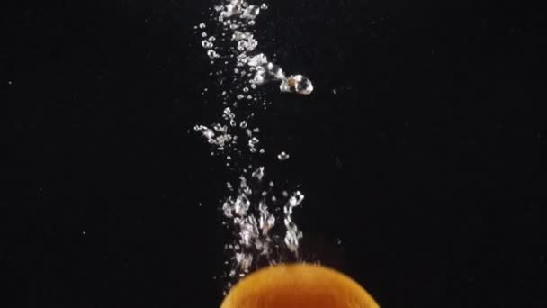 背景の泡が付いている明確な水で落ちるか または落ちるオレンジは広告のためのスペースをコピーします — ストック動画