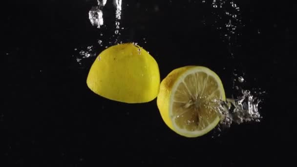 배경에 스플래시와 떨어지는 레몬의 신선한 유기농 절반의 — 비디오