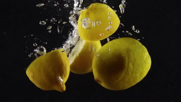 Сочные Половинки Лимонов Брызгами Воды Изолированы Черном Фоне — стоковое видео