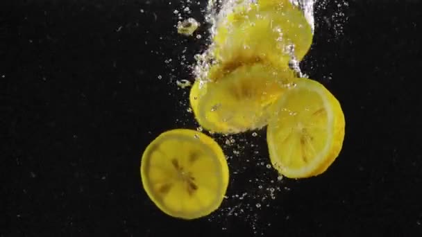 Fette Limone Cadere Cadere Acqua Limpida Con Bolle Sullo Sfondo — Video Stock
