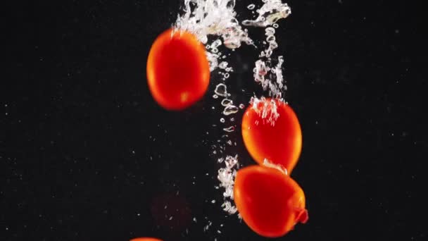 Zbliżenie Czerwonych Pomidorów Wpadających Wody Bąbelkami Izolacji Czarnym Tle Puste — Wideo stockowe