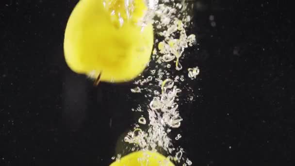 Manzanas Amarillas Maduras Caídas Agua Con Salpicaduras Burbujas Aisladas Sobre — Vídeo de stock