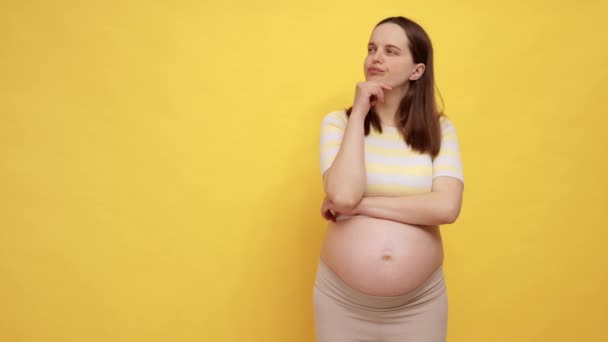 Przemyślana Biała Kobieta Ciąży Gołym Brzuchem Luźnej Bluzce Odizolowana Żółtym — Wideo stockowe