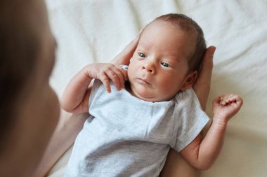 Yakından bakınca, yeni doğmuş oğlunu oynayan genç ve sevecen bir anne, bebeğini emziren annesine tüm sevgisini veriyor.