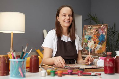 Yetenekli Kafkasyalı ressam, eserleri üzerinde çalışıyor ve atölyesinde soyut bir tasarım çizen yağlı boyayla işinde güzel bir çizim yapıyor.