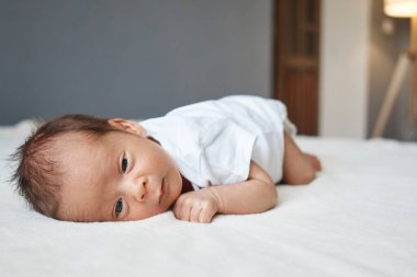 Yatak odasında huzur içinde uyuyan küçük bir bebek, yumuşak bir beşiğinde rahat bir şekilde uzanıyor. Bebek, rahat, sıcak bir yatakta, yumuşak bir battaniyenin içinde uzanıyor.