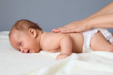 Küçük bir masaj bakımı. Çocuk terapisi. Sağlık ve ilaç. Evde yeni doğmuş bebeğine masaj yapan isimsiz bir anne ya da terapist.