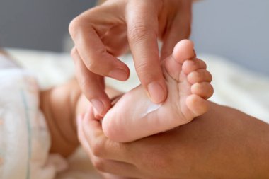 Tanımlanamayan küçük çocuk ya da kız bilinmeyen bir anne ya da doktor yeni doğan bebeğe banyo yaptıktan sonra masaj yapıyor.