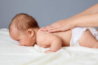 Tanımlanamayan profesyonel masöz bebeğin küçük vücuduna nazik bir terapi uyguluyor. Karnının üstüne yatırıp sağlığına ve kas gevşemesine odaklanıyor.