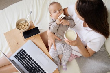 Anne yatak odasında oturup bilgisayar başında çalışırken ya da çocuklar için online alışveriş yaparken ve elinde sakince oynayıp kahvenin tadını çıkarırken.