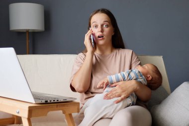Doğum izninde uzaktan çalışan bir kadının yeni doğmuş bir bebekle koltukta oturması ve cep telefonuyla konuşması şaşkınlık verici bir yüz ifadesiyle şok edici bir sürpriz oldu.